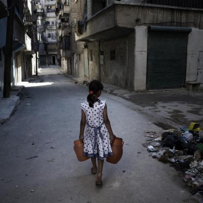 Girl in Syria carries jerry cans
