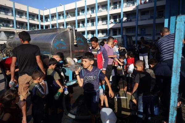 Children in Gaza collect water from truck