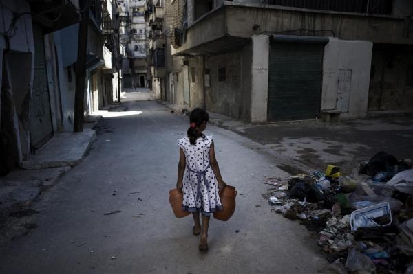 Girl in Syria carries jerry cans