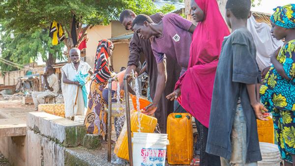 Nigerians access water at a public water point