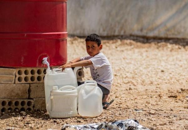 Child fetching water in refugee camp